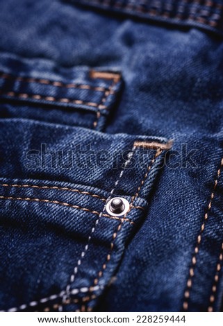 Blue jeans detail, low contrast, toned photo.