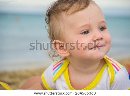 Small child with redness on the skin, suffering from food allergies by the sea