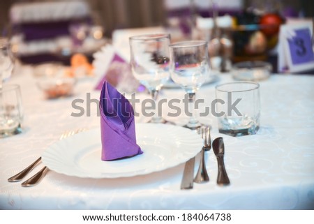 Plate, knife, fork and purple napkin during a wedding
