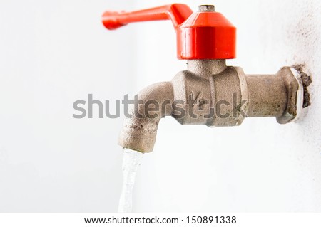 Water leaking from old metal tap isolated on white background