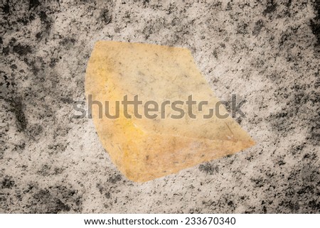triangular piece of cheese with herbs isolated on granite background