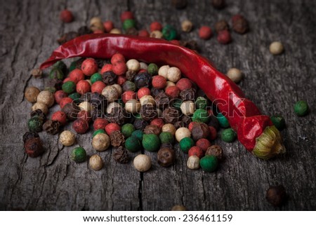 red hot chili peppers and peppercorns on an old wooden table