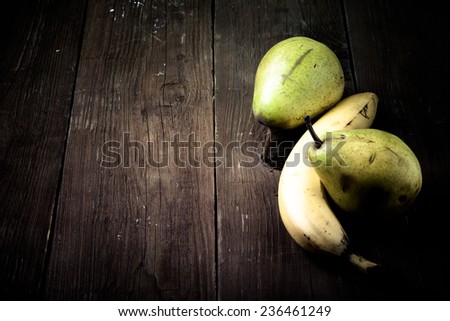 pears, bananas on an old wooden table background