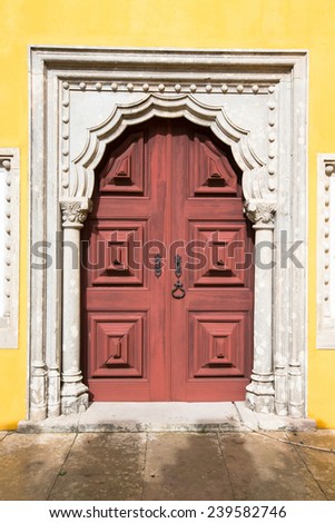 old wooden door framed by a carved stone.