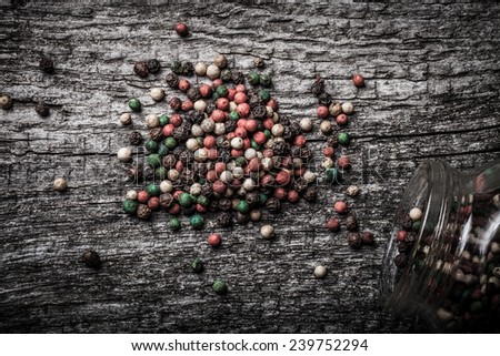 pepper spilled from glass jar on old wooden table