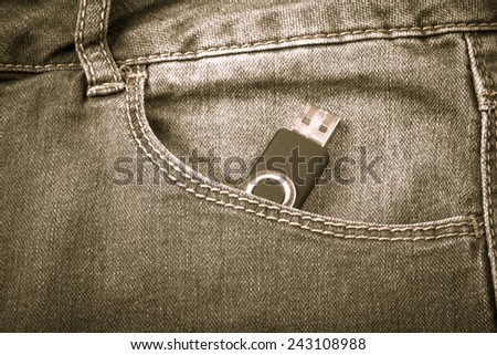 The pocket of jeans with flash card. Cloth background. Toned.