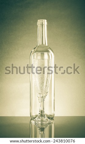 Empty bottle and glass with a pop of transparent glass. Standing each other. With Reflection