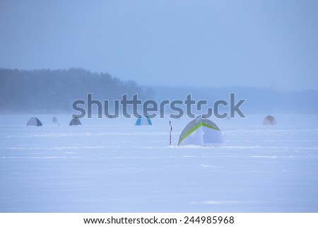 Tents on the snow-covered field near the forest.