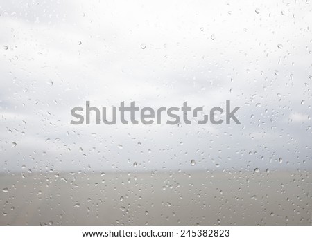 Seaview through the raindrops on window.