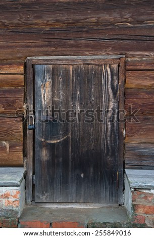 Old wooden door with lock. Foundation of the house of an old red brick.