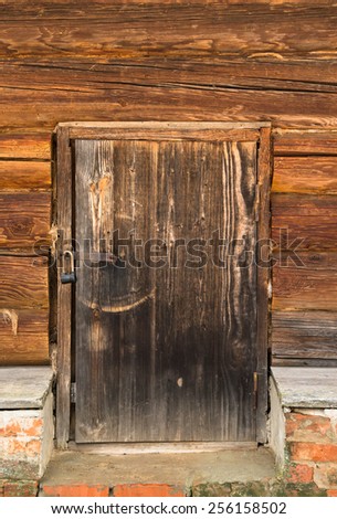 Old wooden door with lock. Foundation of the house of an old red brick. Toned.