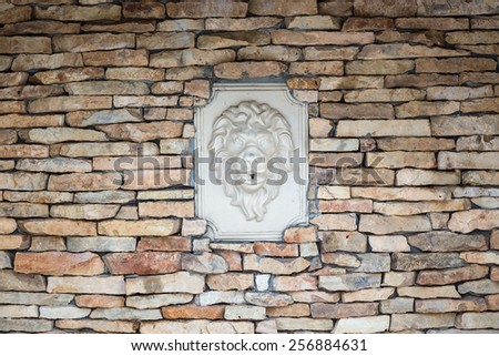 Wall of natural stones with bas-relief of lion.