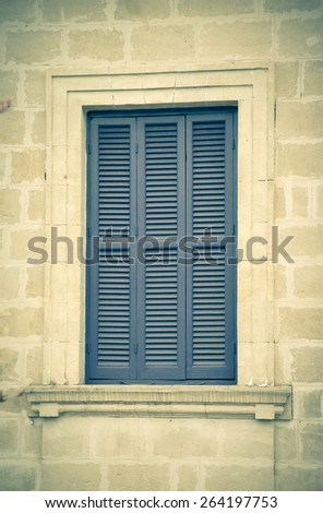 old blue window with shutters closed.