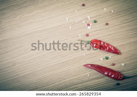Red chili, sea salt and colorful bell pepper on a light wooden table. Toned.
