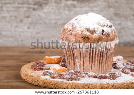 Cake with raisin and sugar powder on the wooden table. Selective focus.