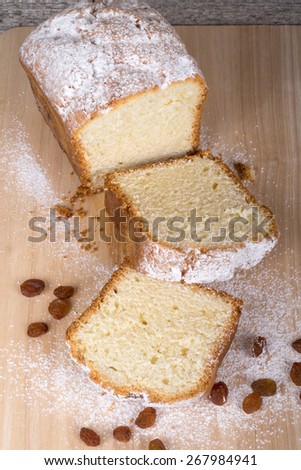 Cake with raisin and sugar powder on the wooden table. Selective focus.