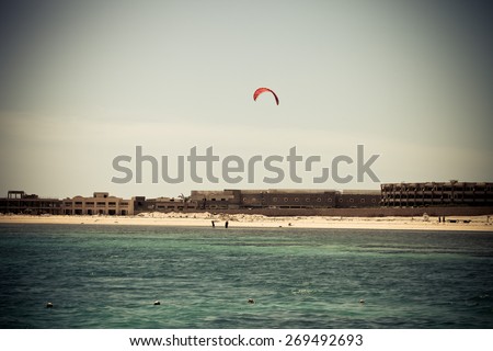 Kiter in the lagoon of the Red Sea on the background of an unfinished hotel. Egypt, Sharm El Sheikh. Toned.