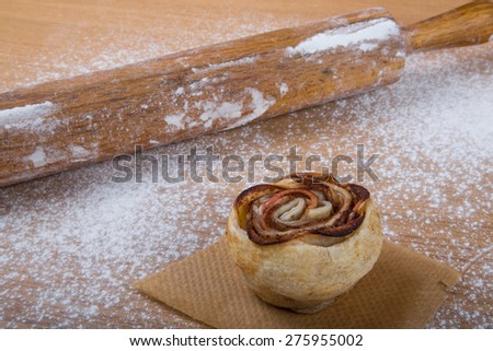 Homemade pastries on a light wooden table with flour.