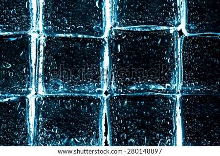 Wall of wet Ice cubes on black background. Selective focus. Toned.