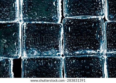 Wall of wet Ice cubes on black background. Selective focus. Toned.