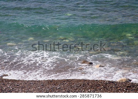 Pebble beach and blue water of the Mediterranean Sea.