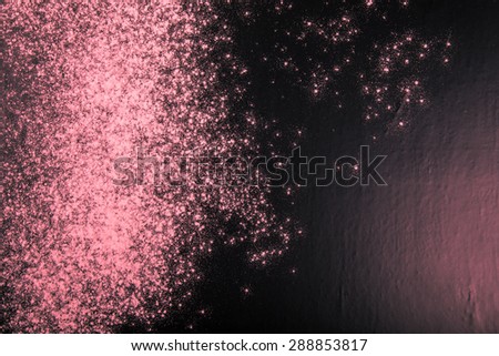 Flour spilling on black background. Toned pink. Culinary galaxy.