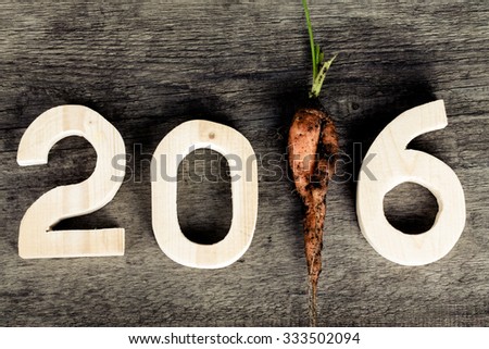 2016 on old grey wooden background with dirty fresh carrot instead digit 1 (one). Christmass theme. Billet for postcard or calendar. Toned.