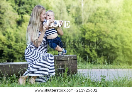 Sweet baby and mom outdoors. kid with mum with the words love