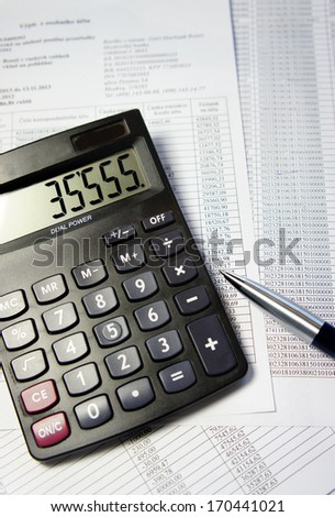 Calculator, pen and accounting document with a lot of numbers