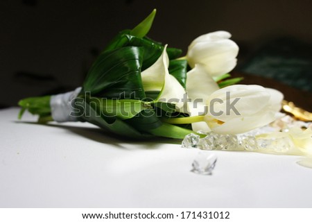 Beautiful wedding bouquet of white callas and tulips lying on the table