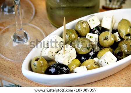 Mix of green and black olives on the table with wine