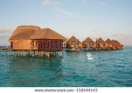 the sun rise over water bungalows in amazing water villas
