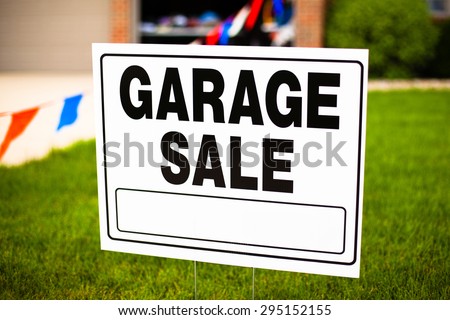 Garage sale sign on the front yard of a suburban house