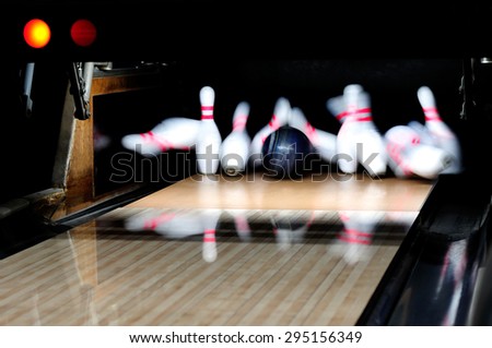 Picture of  bowling ball hitting pins scoring a strike