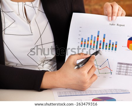 Marketing executive making a business presentation and analyzing sales report with charts and graphs