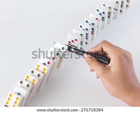 Human hand stopping a line of dominoes from falling. concept image for strategy and solution for cascading failures and problems.