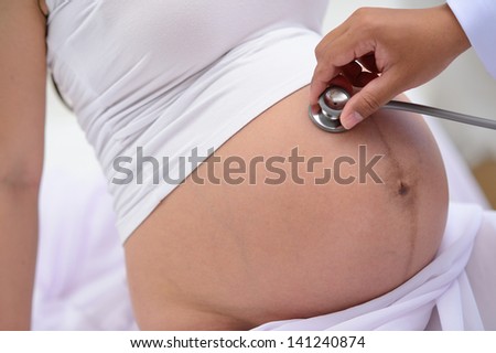 doctor listen big stomach pregnant woman