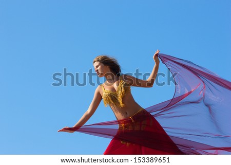 beautiful girl in east dress on background sky