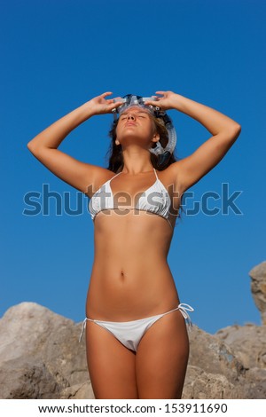 Girl with goggles, and snorkel smiling in summer bikini