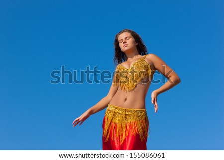beautiful girl in east dress on background sky