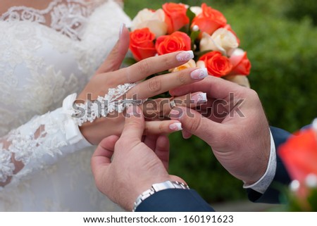 Bridegroom and wedding ring on finger of the bride