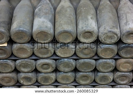 Old bottles of wine in rows in wine cellar