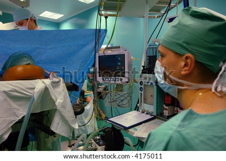 anesthetist with a face-piece monitoring the patient during breast reduction