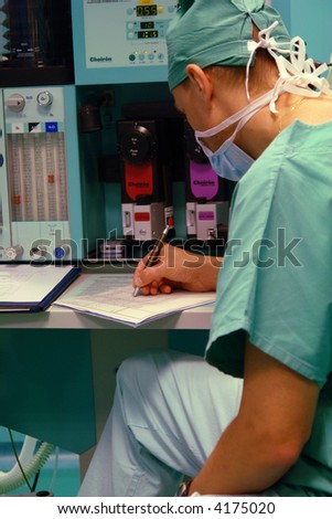 detail of anesthetist writing down the data form monitoring the patient
