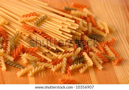 Raw colour pasta background on yellow wooden cook-table