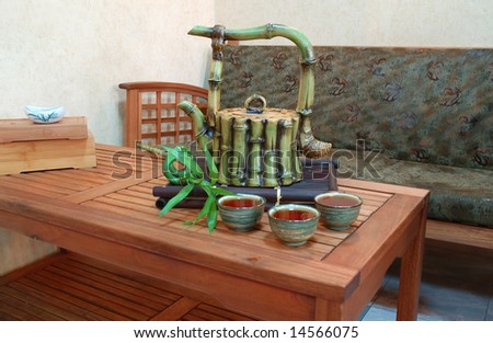 Chinese tea in antique bowls with bamboo and teapot. Interior of japanese or chinese restaurant.