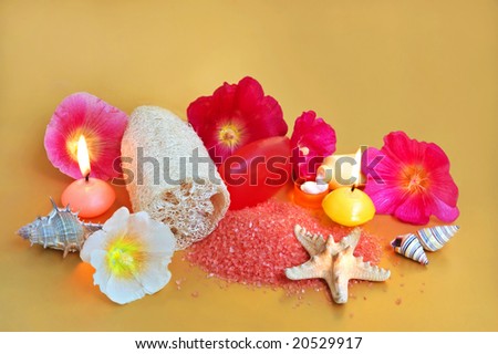 Still life of beauty treatment items with aromatherapy candles, loofah, cream, salt and soaps.
