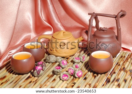 Chinese teapots and cups on a beige satin background