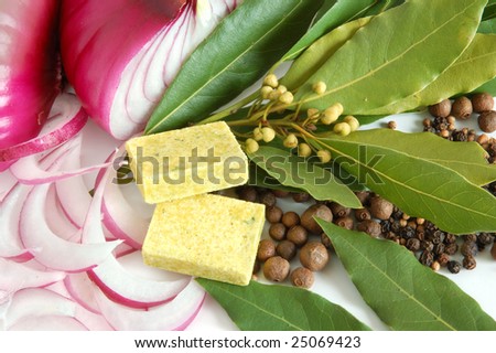 Fresh bay leaves, red onion, bouillon cube, whole black pepper and white coriander isolated on white