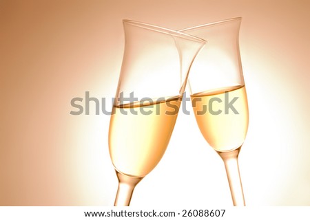 Pair of champagne flutes on orange background